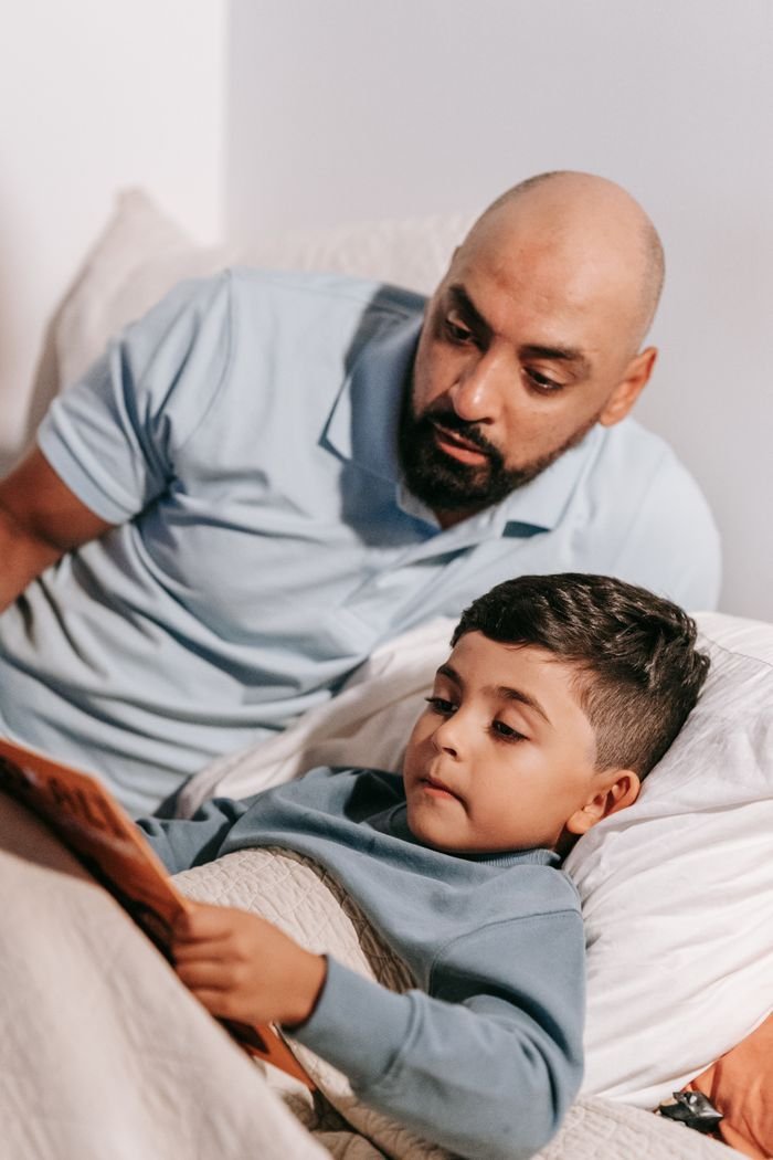 Een vader leest voor aan zijn zoon in bed