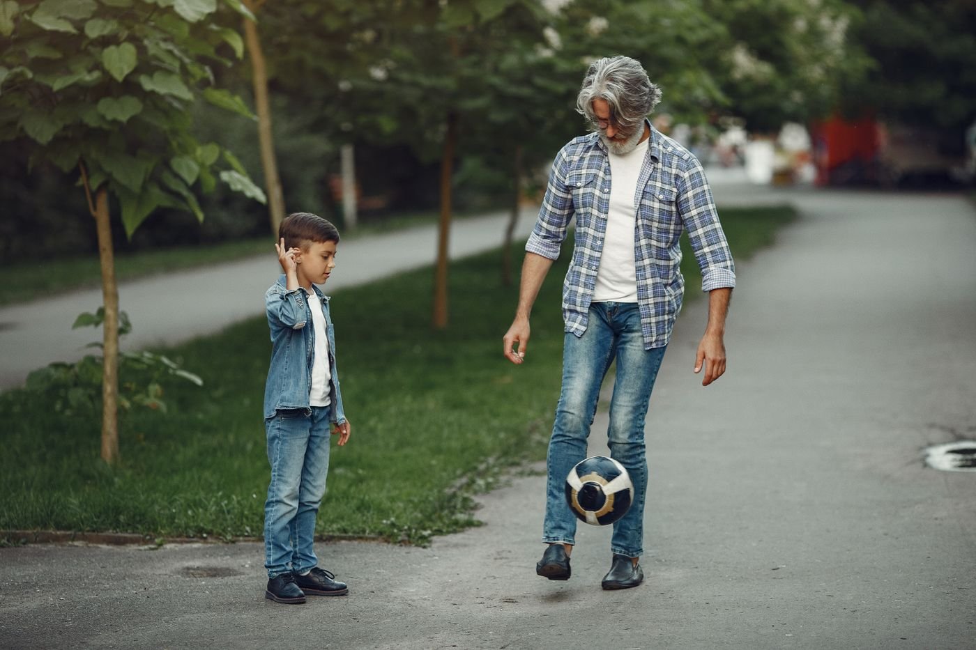 Opa en kleinzoon voetballen samen buiten