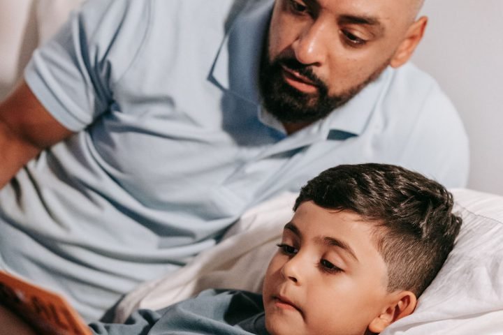 Vader leest zijn zoon voor in bed